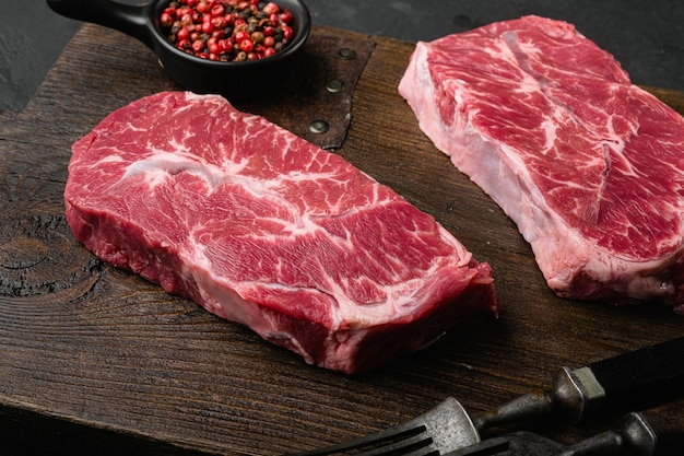 写真 黒い暗い石のテーブルの背景にカットされた肩の上の刃の牛肉の肉