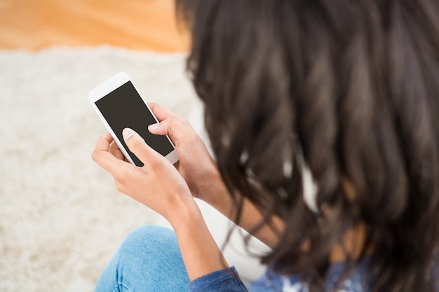 Vista sopra la spalla della donna casual usando il suo smartphone