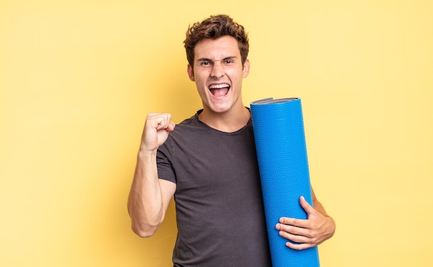 Shouting aggressively with an angry expression or with fists clenched celebrating success. yoga mat concept