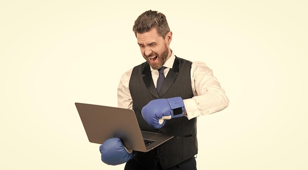 Shouting guy in boxing gloves and formalwear punch computer isolated on white cyber bullying