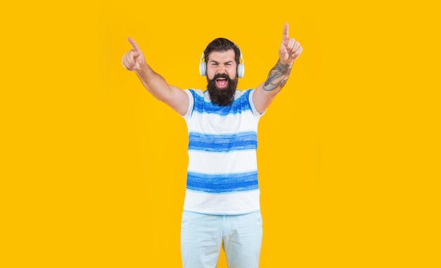 Shouting guy in cool earphones listening music studio shot of cool guy with earphones