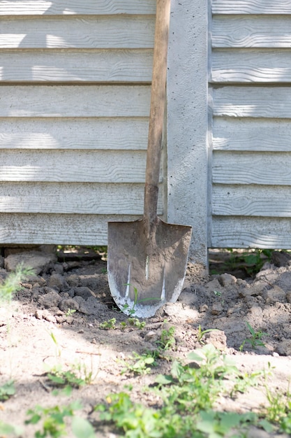Photo shovel on the background of the wall in the garden