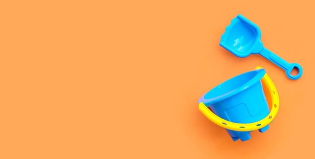 Shovel and bucket for sand on orange surface