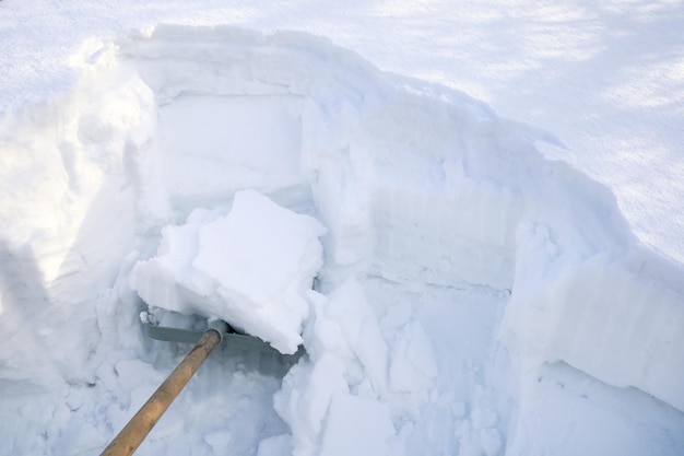 シャベルはたくさんの雪でいっぱいです きれいな道路 雪の多い冬