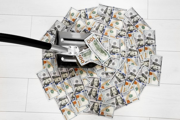 Shovel lifts dollar bills on floor