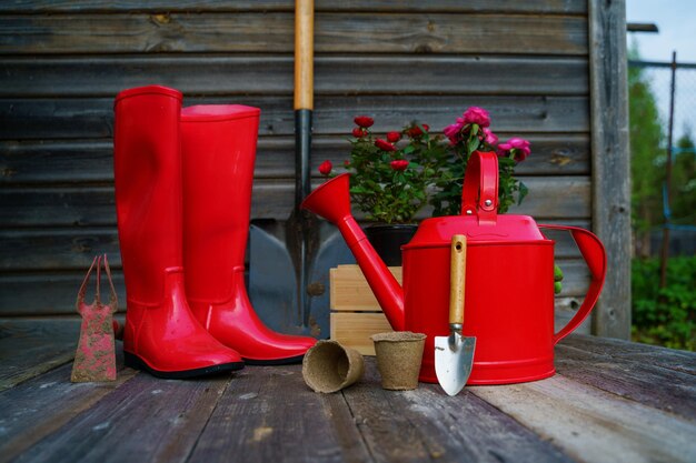 Shovel watering can hat rubber boots box of flowers gloves and garden tools