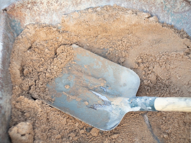 Shovel with sand for laying bricks on a construction site