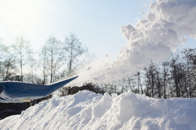 Spalare la neve in una giornata invernale di sole. rimozione della neve dal vialetto