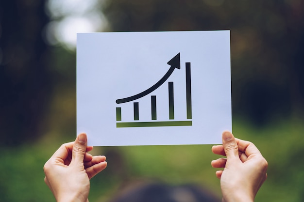 Show business paper graph statistics,arrow showing the chart in hand