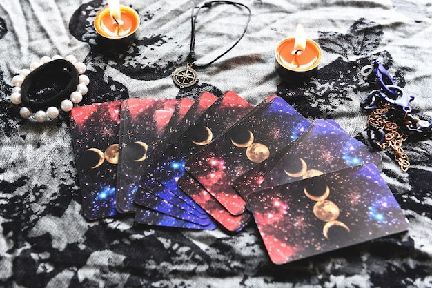 Show fortune tellers of hands holding tarot cards and tarot reader with candle light on the table, Performing readings magical performances, Things mystical astrologists forecasting concept