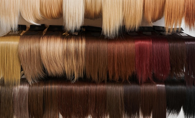 Photo showcase of natural looking wigs in different colors in beauty salon variation shades of hair on shelf in wig shop