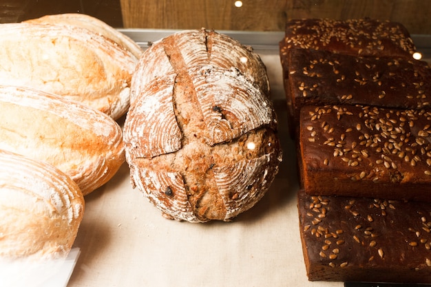 Foto vetrina con diversi tipi di pane fresco fatto a mano. forno