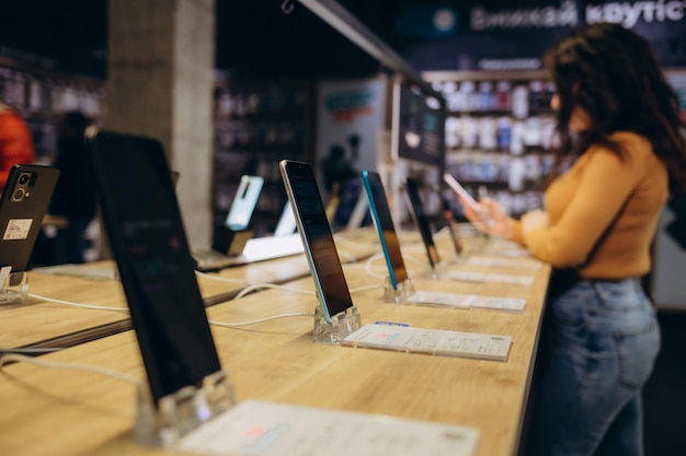 Showcase with smartphones in the modern electronics store Buy a mobile phone Many smartphones on the shelf of the technology store