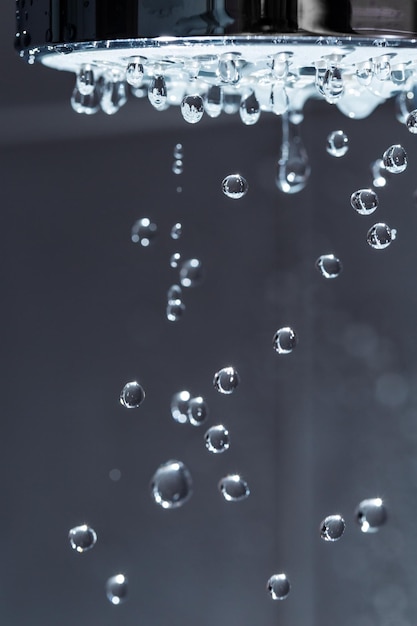 Shower Head with Water Stream on Black Background