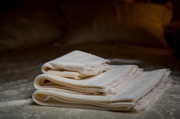 shower towels stacked on a bed White linens and towels set in a modern hotel