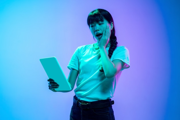 Foto mostrando lo schermo del telefono vuoto ritratto di giovane donna asiatica su gradiente bluepurple studio