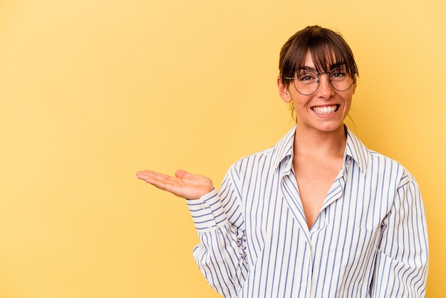 Showing a copy space on a palm and holding another hand on waist