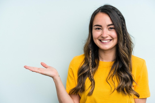 Showing a copy space on a palm and holding another hand on waist