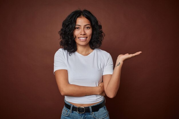 Showing a copy space on a palm and holding another hand on waist