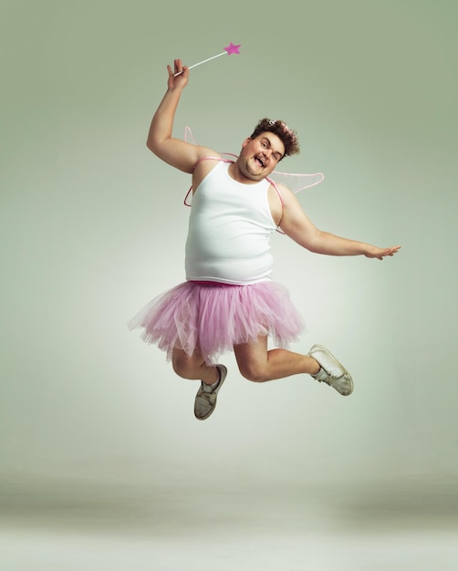 Photo showing his lighter side an overweight man comically dressedup in a pink fairy costume