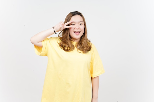 Знак мира красивой азиатки в желтой футболке на белом фоне