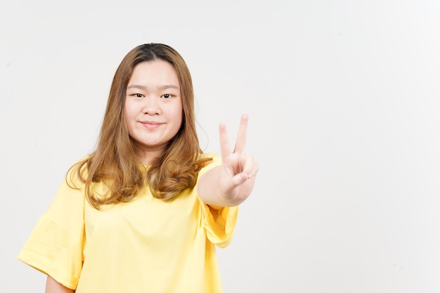 Знак мира красивой азиатки в желтой футболке на белом фоне