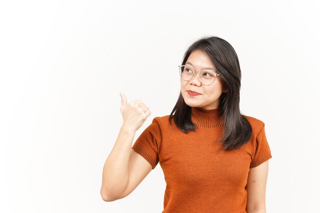 Showing and Pointing Product With Thumbs Of Beautiful Asian Woman Isolated On White Background