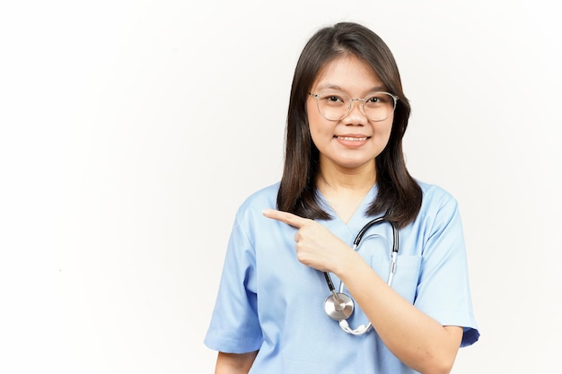 Showing Product and Pointing Side Of Asian Young Doctor Isolated On White Background