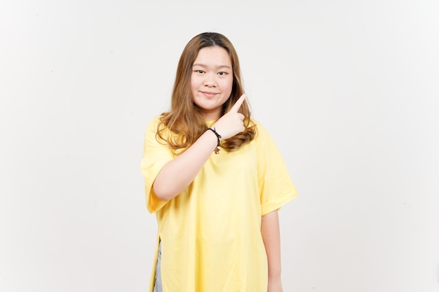 Showing Product and Pointing Side of Beautiful Asian Woman wearing yellow TShirt Isolated On White