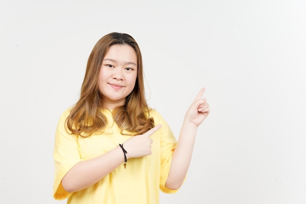 Showing Product and Pointing Side of Beautiful Asian Woman wearing yellow TShirt Isolated On White