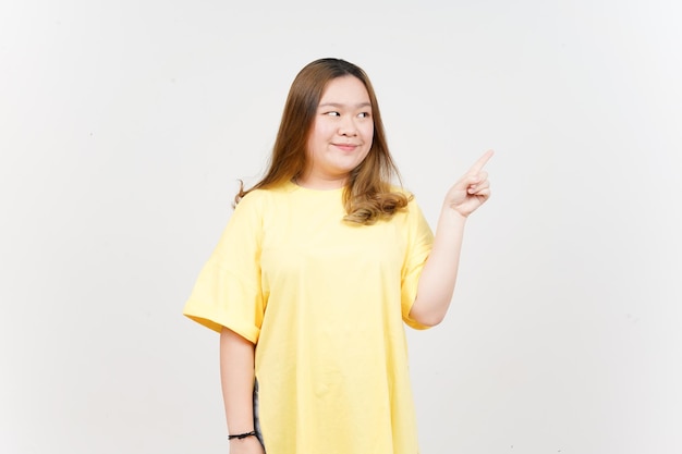 Showing Product and Pointing Side of Beautiful Asian Woman wearing yellow TShirt Isolated On White