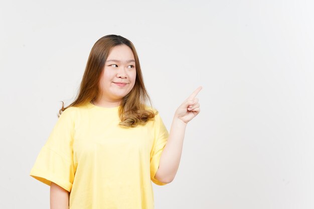 Showing Product and Pointing Side of Beautiful Asian Woman wearing yellow TShirt Isolated On White