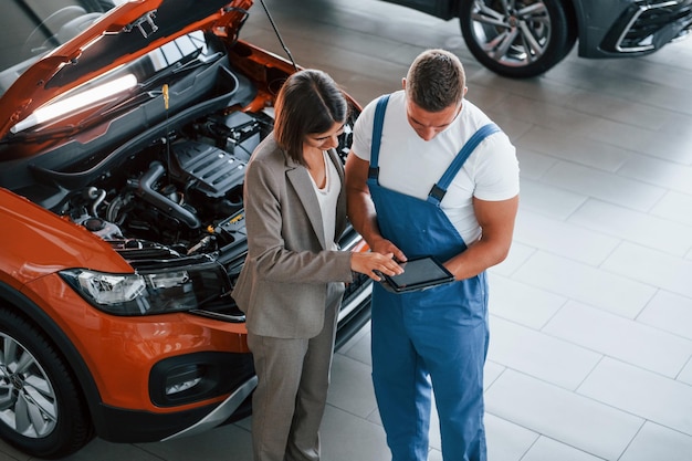 Visualizzazione dei risultati del lavoro uomo che ripara l'automobile della donna all'interno servizio professionale