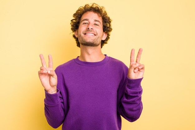 Showing victory sign and smiling broadly