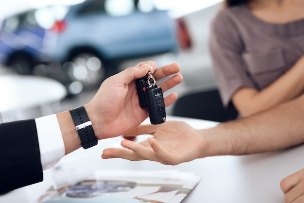 Showroom Dealer The Gives Car Keys To The Buyer.