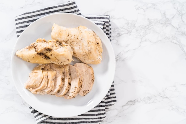 Shredded chicken in a pressure cooker Freshly cooked chicken breasts on a white plate