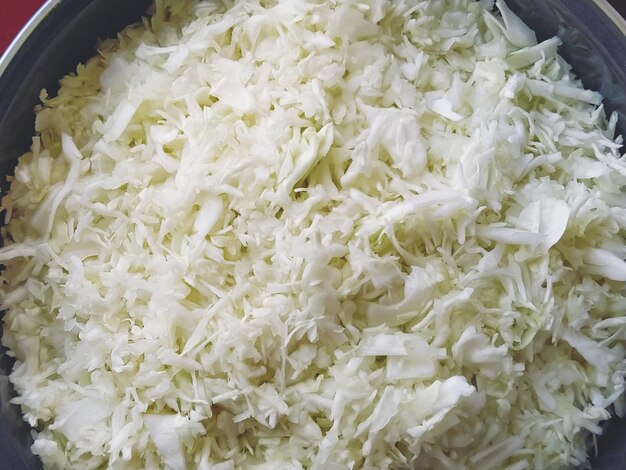 鍋に細かく刻んだ白キャベツ緑の野菜サラダのクローズアップベジタリアンキャベツサラダ