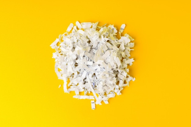 Photo shredded white paper on light yellow background