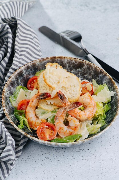 Shrimp bread lettuce cherry tomatoes and cheese in a bowl of\
salad