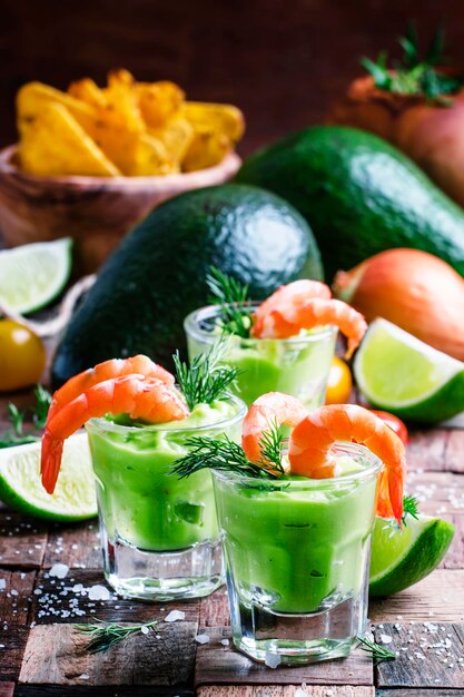 Shrimp cocktail with avocado sauce and lime vintage wooden background selective focus