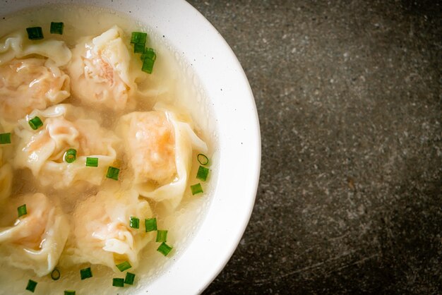 Shrimp dumpling soup in white bowl