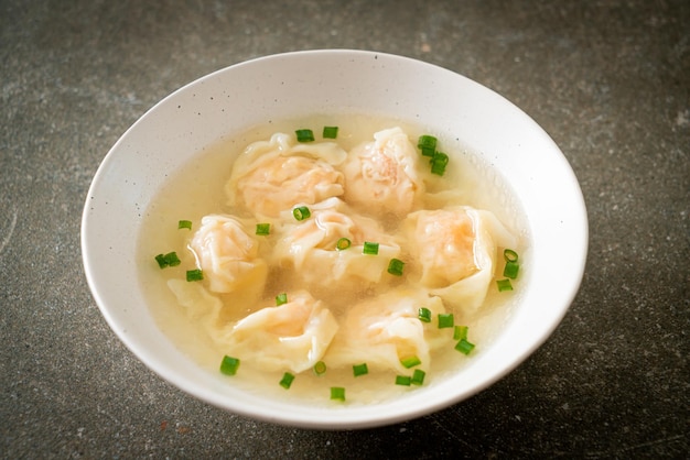 Shrimp dumpling soup in white bowl