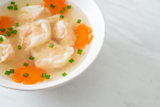 Shrimp dumpling soup in white bowl