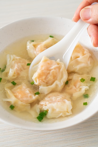 Shrimp dumpling soup in white bowl