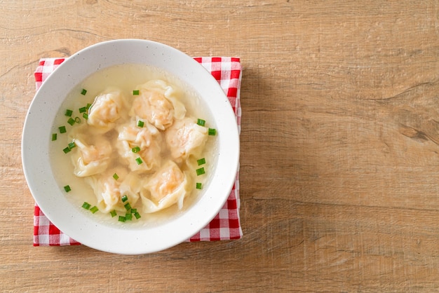 Shrimp dumpling soup in white bowl