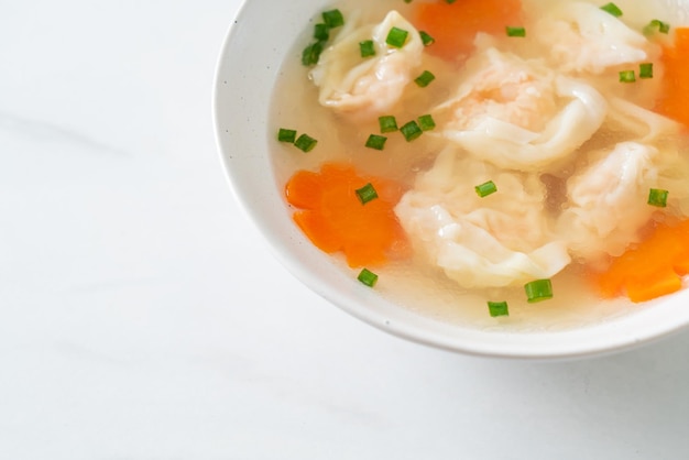 Shrimp dumpling soup in white bowl