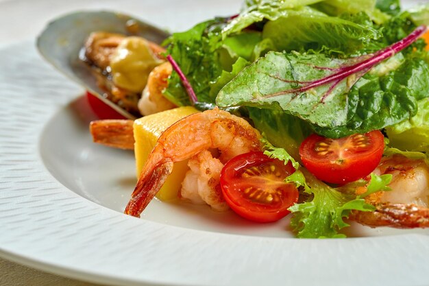 エビとムール貝のサラダ、テーブルクロスの白い皿にマンゴー