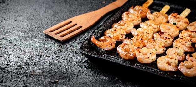 写真 串焼きのエビをグリル鍋で焼きます