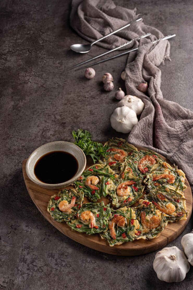Shrimp pancakes with soy sauce on a black surface board