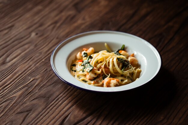 木製のカウンターでエビのパスタ麺